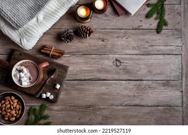 Hot coffee drink, almonds, cosy knitted sweater on wooden background with candles and pine cones, copy space. Hygge and home comfort concept. Seasonal winter cosy composition. - Powered by Shutterstock