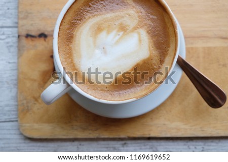 Hot coffee latte. Latte art is a method of preparing coffee created by pouring micro foam into a shot of espresso and resulting in a pattern or design on the surface of the latte.