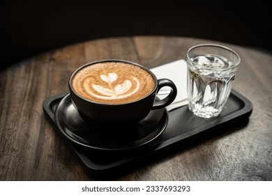 Hot coffee latte with latte art milk foam in cup mug on wood desk on top view. As breakfast In a coffee shop at the cafe,during business work concept,vintage style