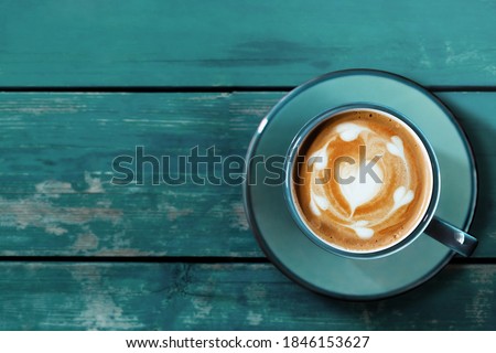 Hot Coffee Latte Cup on Blue Wooden Table. Top View. Latte Art in Heart Shape