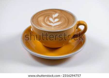 hot coffee latte with foam in yellow ceramic cup on white background