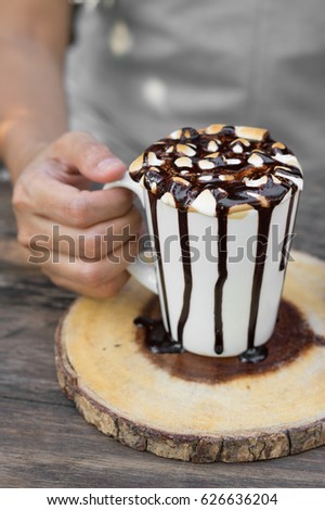 Hot coffee with marshmallow cup in woman hand..