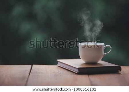Hot coffee, smoke, with books for note taking with beautiful nature background.