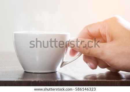 Similar – Foto Bild Frau Hand, die eine Tasse Kaffee von einem Holztisch im Garten aufzieht.