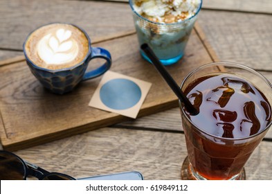 Hot And Cold Drinks Stand On A Wooden Table. Everyone Chooses Their Favorite Drink.