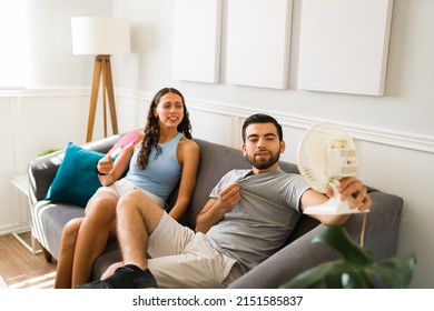 Hot Couple With No Air Conditioner Using A Small Electric Fan To Cool Down Because Of A Hot Summer 