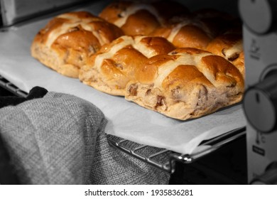 Hot Cross Buns Cooked In An Electric Oven.  Taken Out By A Person Wearing Oven Gloves