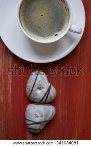 hot cup of coffee with couple of heart shaped chocolate cookies.