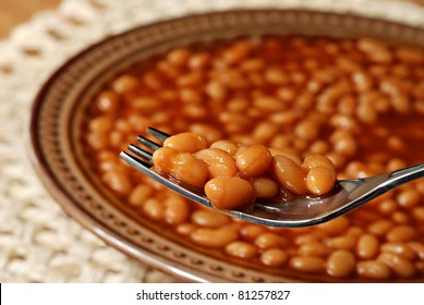 Hot Delicious Baked Beans On Fork With Bowl Of Beans In Soft Focus In Background.  Macro With Extremely Shallow Dof.
