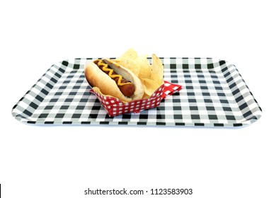 Hot Dog. Hot Dog In Bun And Potato Chips With Mustard Squiggle On A Black And White Checker Serving Tray. Isolated On White. Room For Text. 