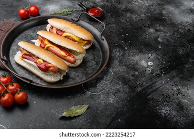 Hot dog grilled sausage in a bun with sauces, on black dark stone table background, with copy space for text. - Powered by Shutterstock