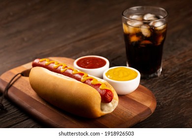 Hot dog with ketchup, yellow mustard and soda. Image with selective focus. - Powered by Shutterstock