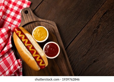 Hot dog with ketchup and yellow mustard. Image with selective focus.