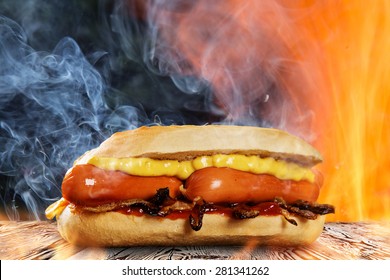 Hot Dog With Mustard And Ketchup On Wooden Table With Fire Flames Background.