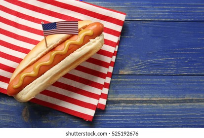 Hot Dog With Mustard And Small USA Flag On Napkin