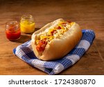 hot dog on blue fabric with two little jars with mustard and ketchup 