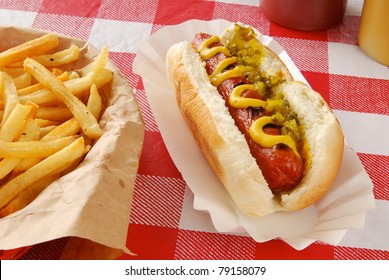 A Hot Dog With Relish And A Basket Of Fries