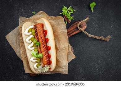 hot dog sandwich sausage, gherkin, ketchup, mayonnaise fast food smeal food snack on the table copy space food background rustic top view - Powered by Shutterstock