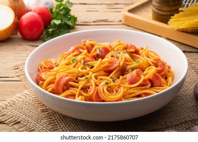 Hot dog or sausage stuffed with spaghetti in tomato pork sauce in white plate - Shutterstock ID 2175860707