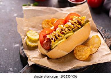 Hot dog with tomatoes and pickles, onion and fennel seeds