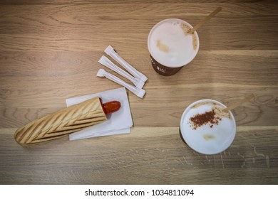 Hot Dog And Two Cups Of Coffee On Wooden Table, Focus On Ho Dog