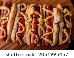 Hot dogs. Bratwurst, a pork sausage in a hot dog bun topped with classic condiments mustard, ketchup and sauerkraut. Classic traditional American baseball game ballpark concession stand item.