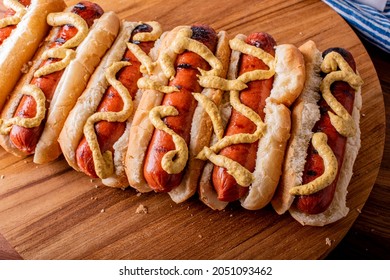 Hot Dogs. Bratwurst, A Pork Sausage In A Hot Dog Bun Topped With Classic Condiments Mustard, Ketchup And Sauerkraut. Classic Traditional American Baseball Game Ballpark Concession Stand Item.