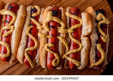 Hot Dogs. Bratwurst, A Pork Sausage In A Hot Dog Bun Topped With Classic Condiments Mustard, Ketchup And Sauerkraut. Classic Traditional American Baseball Game Ballpark Concession Stand Item.