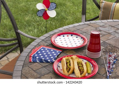 Hot Dogs At A July 4th Cookout Are Dressed With Ketchup, Mustard And Relish And Are Served With Potato Chips And A Pickle.  This Image Is In One In A Series Of Patriotically Themed Images.