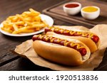 Hot dogs with ketchup, yellow mustard, fries and soda. Image with selective focus.