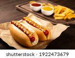 Hot dogs with ketchup, yellow mustard and fries. Image with selective focus