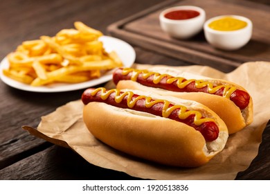 Hot dogs with ketchup, yellow mustard, fries and soda. Image with selective focus.