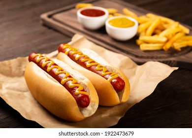 Perros calientes con ketchup, mostaza amarilla, papas fritas y refrescos. Imagen con enfoque selectivo