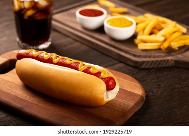 Hot dogs with ketchup, yellow mustard, french fries and soda. Image with selective focus