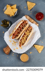 hot dogs with pickles, bacon and nachos on a gray background, selective focus - Shutterstock ID 2270309079