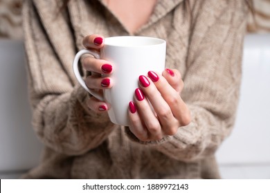 Hot drink in a beautiful manicured hand in winter