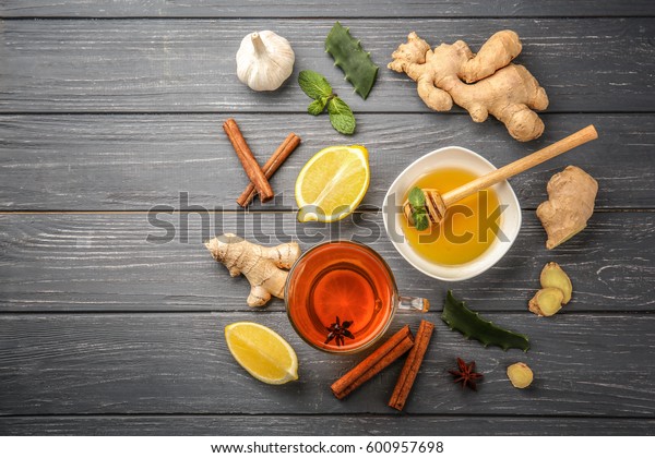 Hot drink with honey, lemon and ginger for cough\
remedy on wooden table