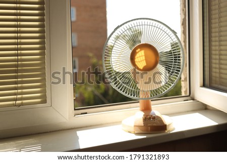 Hot. Electric ventilator - fan is on the windowsill, the window is open