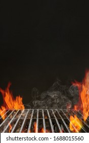 Hot empty barbecue BBQ grill with bright flaming fire, ember charcoal and smoke on black background. Waiting for the placement of your food. Close up