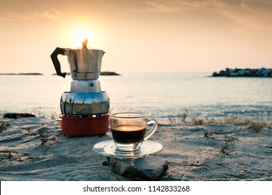 Hot Esspresso Shot Or Hot Black Coffee From Mokka Pot  Ready To Serve At Freshy Morning Time On The Beach Outdoor Activity.black Coffee Ready To Drink From Mug On The Beach Outdoor Picnic.