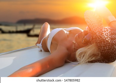 Hot fit woman on her yacht at sunset in Thailand