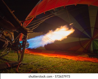 Hot flames bursts into the hot air balloon, getting ready for the ascent. - Shutterstock ID 572637973