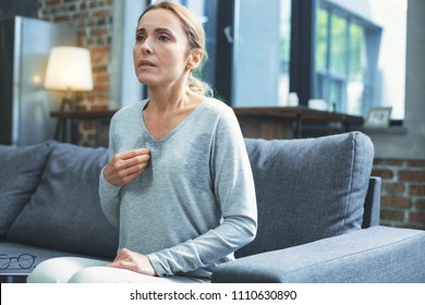 Hot Flashes. Exhausted Mature Woman Resting On Sofa And Having Hot Flash