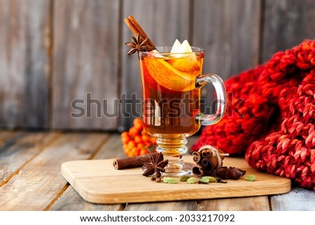 Hot fruit homemade tea with fresh apples, honey, spices: cinnamon, cardamon, anise, clove. Warm autumn drink, delicious healthy beverage. Mulled wine. Cozy fall home atmosphere. Wooden background