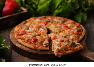 Hot Fuming Pizza On A Wooden Table With Cheese Stretch ,cheese String With All The Ingredients Closeup With Selective Focus And Blur