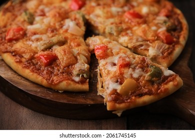 Hot Fuming Pizza On A Wooden Table With Cheese Stretch ,cheese String With All The Ingredients Closeup With Selective Focus And Blur