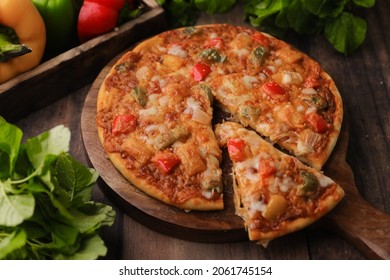 Hot Fuming Pizza On A Wooden Table With Cheese Stretch ,cheese String With All The Ingredients Closeup With Selective Focus And Blur