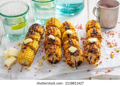 Hot grilled corn cob with butter and salt. Grilled cob served with butter and salt.