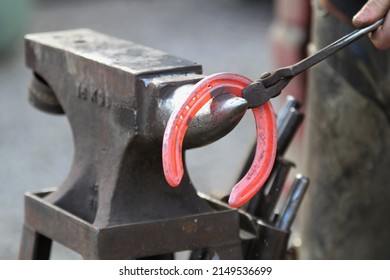 Hot horseshoe about to be worked by a farrier ready to be put onto horse. Equestrian UK 