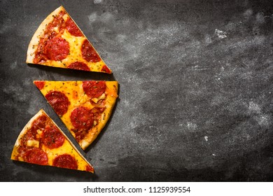 Hot Italian Pepperoni Pizza Slice On Black Stone. Top View. Copyspace